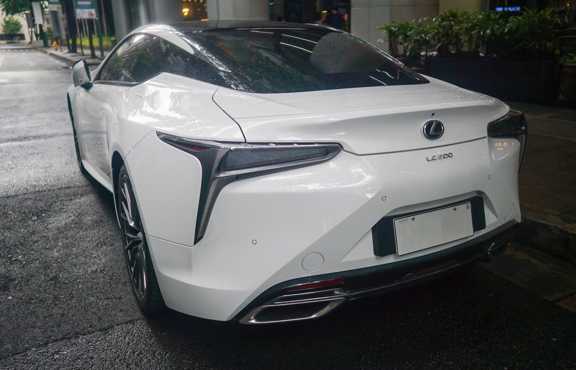ညဘက် မိုးစင်းကျနေသော မြို့လမ်းပေါ်ရှိ Lexus LC 500